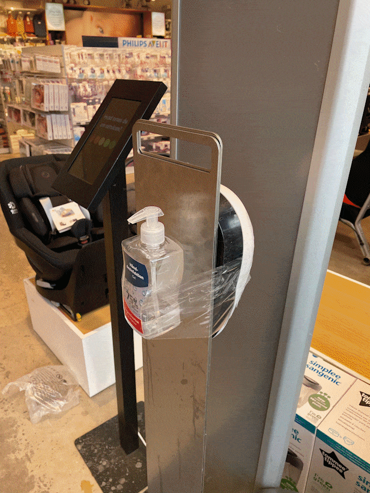 Makeshift hand sanitizer taped to a stand in a retail aisle, illustrating improvised hygiene during the pandemic