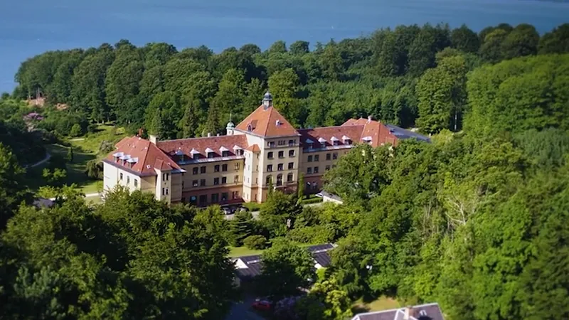Aerial view of Hotel Vejlefjord surrounded by forest