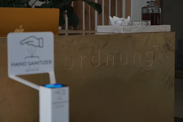 White Geysier dispenser in front of the brass counter at Ordnung